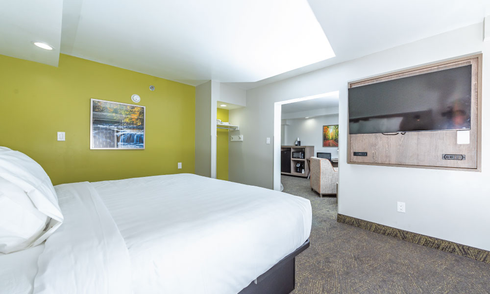 A suite with one king bed, fireplace and whirlpool.  View of second room with king bed.